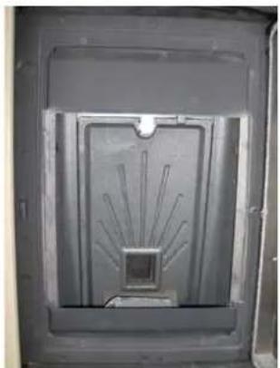 Interior view of a dark rectangular enclosure with a central circular structure and radial lines, no visible text or symbols.