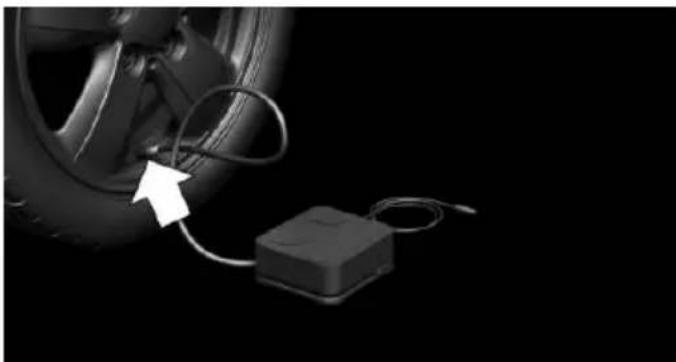 Close-up of a car wheel connected to a small electronic device (no visible text or symbols)