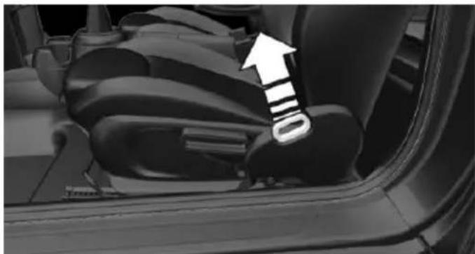 Close-up of a car's rear seatbelt mechanism with an arrow pointing to the side panel (no text or symbols visible)