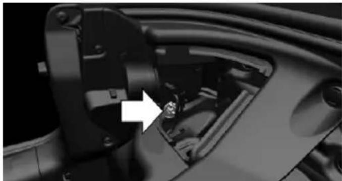 Close-up of a mechanical component with a white arrow pointing to a small metallic part (no visible text or symbols)