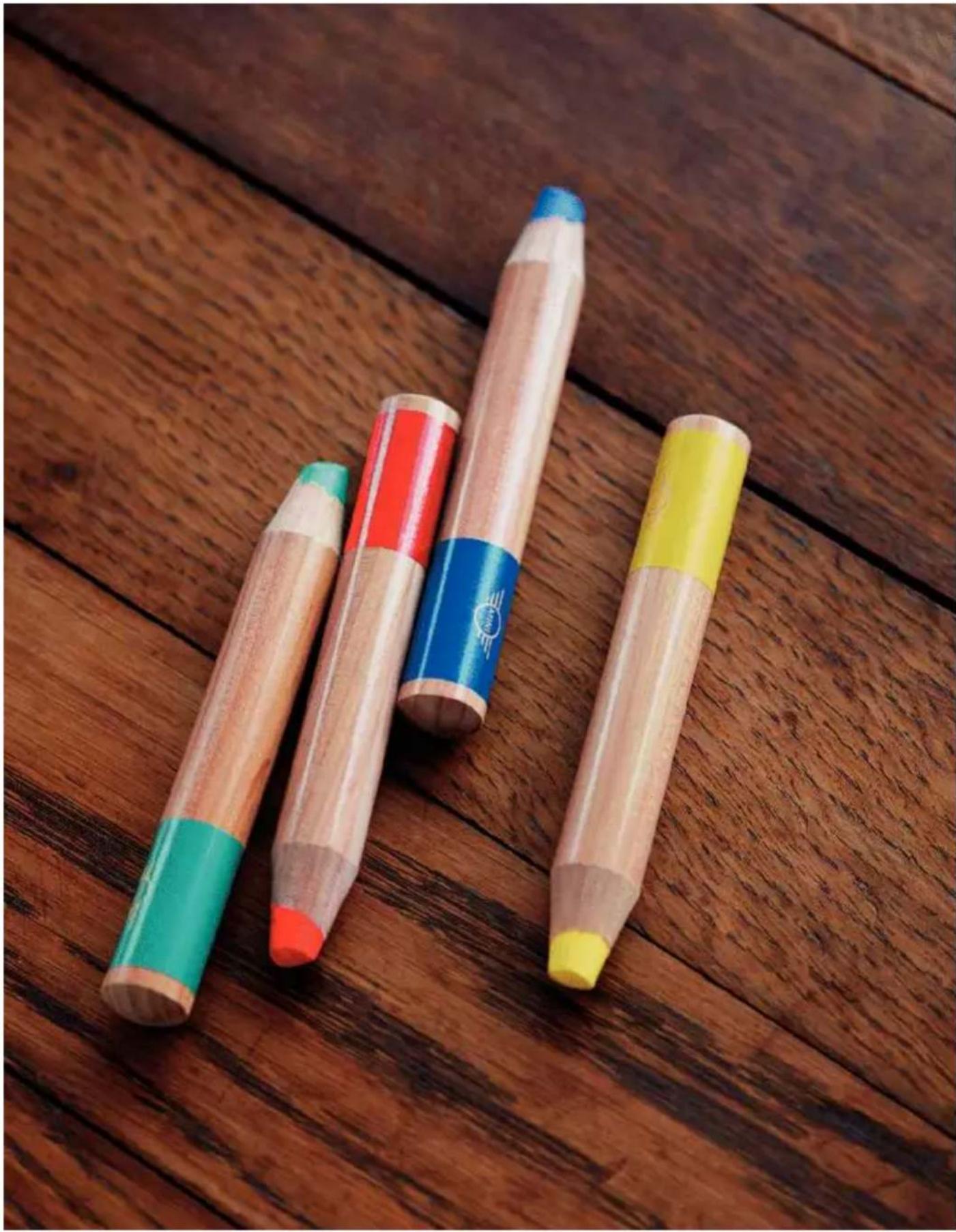 Three wooden pencils with colored erasers placed on a wooden surface (no text or symbols visible)