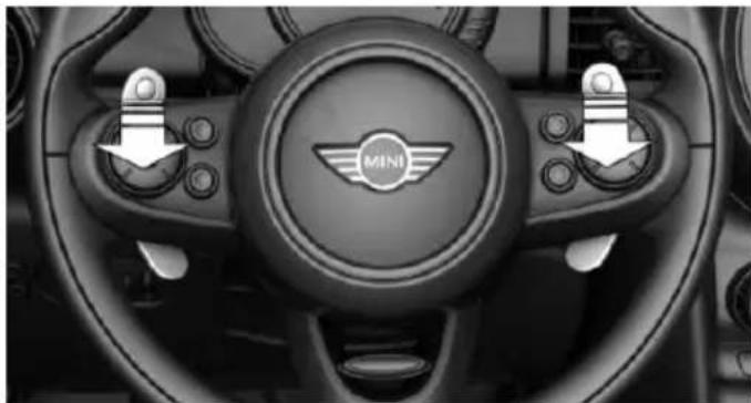 Interior view of a car dashboard with the Mini Motor, showing steering wheel and control buttons (no readable text or symbols)