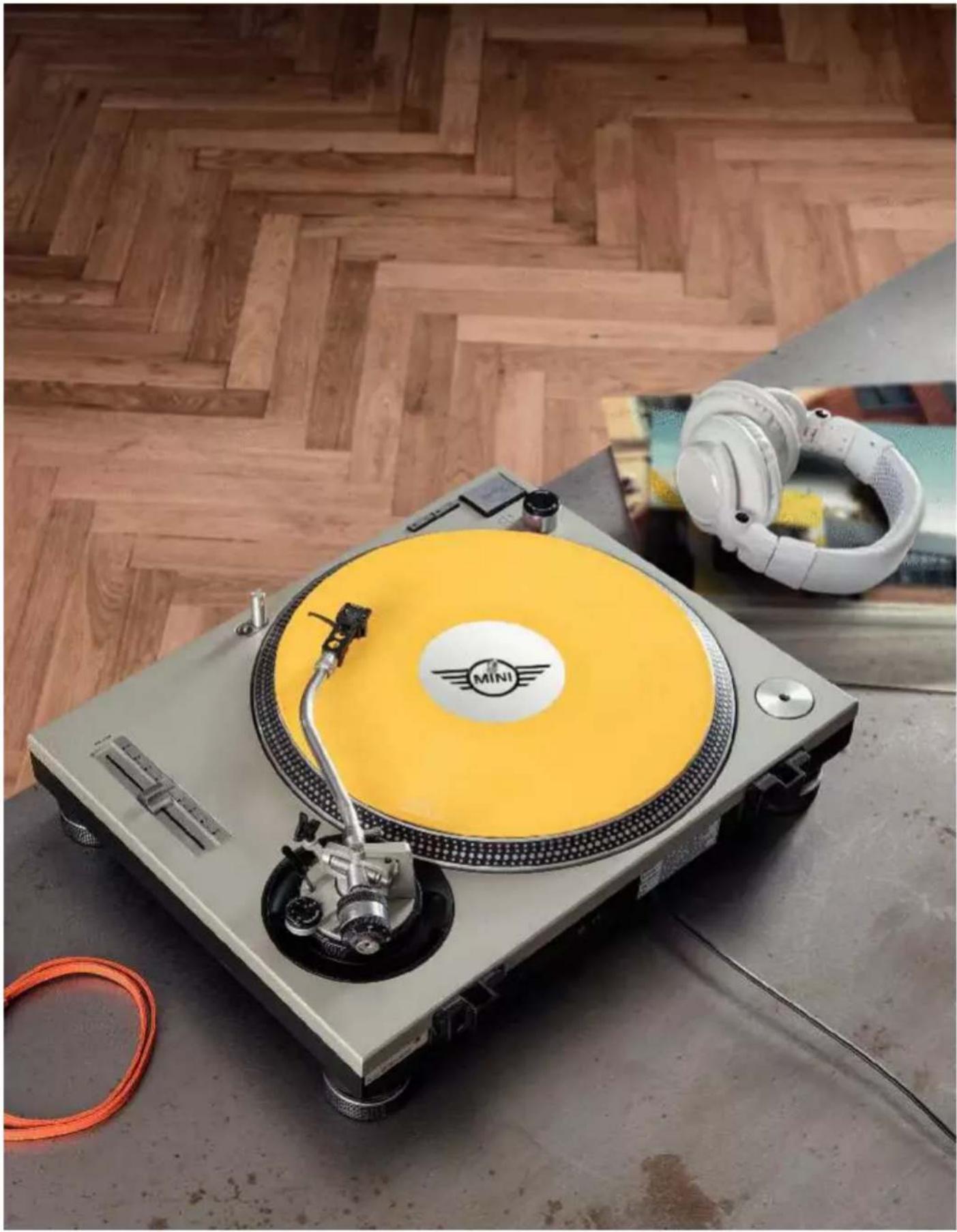 Top view of a Mini Club music<|im_start|> Puerto Rico dapper machine on a workbench, with wooden flooring and earpieces in the background (no visible text or symbols)