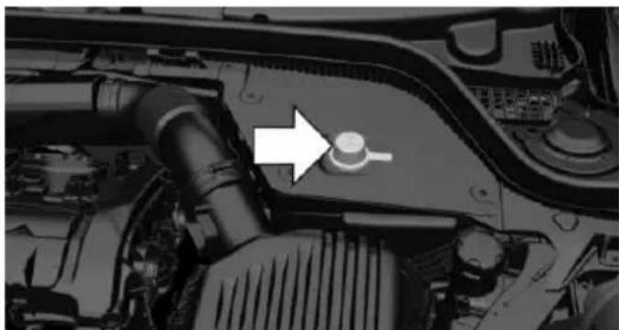 Close-up of a car engine bay with a white arrow pointing to a component (no visible text or symbols)