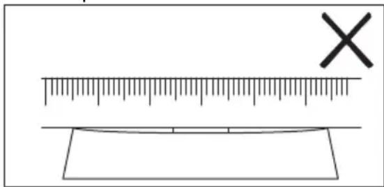 Diagram showing a ruler measuring a rectangular object with a cross mark symbol, likely illustrating a measurement or calibration concept.