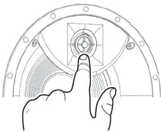 Line drawing of a hand pressing down on a mechanical component with concentric rings and mounting holes (no text or symbols)
