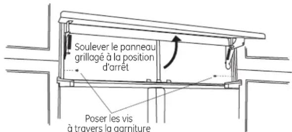 Soulever le panneau grillagé à la position d'arrêt Poser les vis à travers la garniture