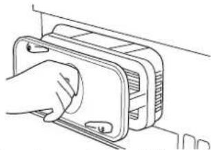 Line drawing of a hand inserting a component into a device (no text or symbols)