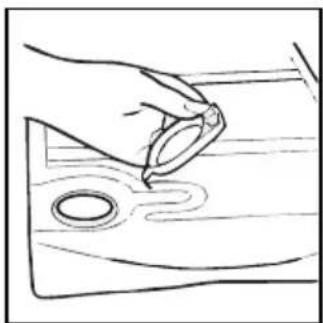 Line drawing of a hand holding a ring above a wooden surface with a circular hole (no text or symbols)