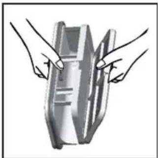Illustration of two hands holding a rectangular object with internal markings (no text or symbols)