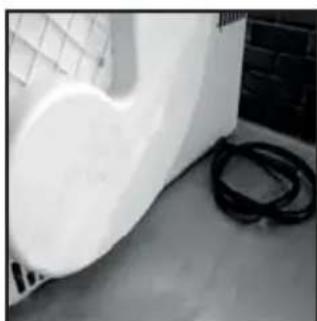 Interior corner of a room with a white wall and black rope, no visible text or symbols