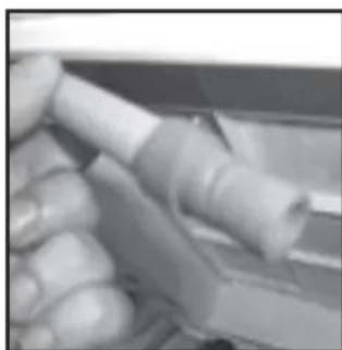 Close-up of a hand holding a white cylindrical object, possibly a tool or component (no visible text or symbols)