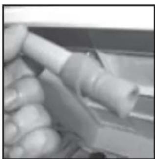 Close-up of a hand holding a white cylindrical object, possibly a plug or connector (no visible text or symbols)