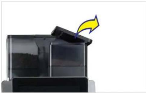 Close-up of a black plastic container with a yellow arrow pointing upward, no visible text or symbols.