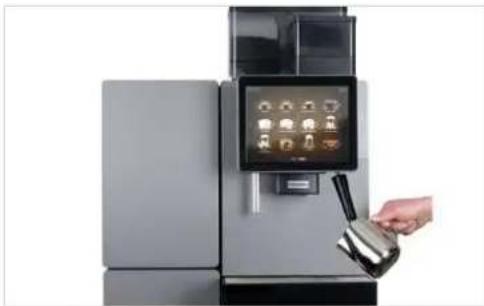 Hand pouring liquid into a modern kitchen appliance with digital display (no visible text or symbols).