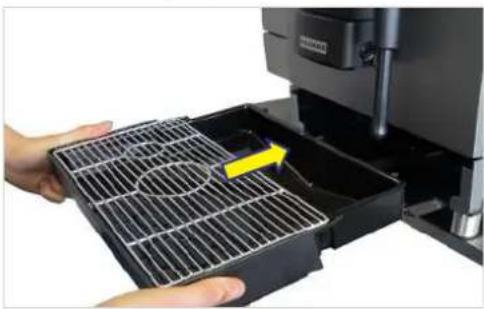 Close-up of hands handling a black plastic grating with a yellow arrow pointing to a component (no visible text or symbols).