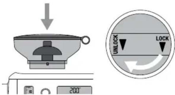 Diagram showing a kitchen appliance with a downward arrow and a circular lock mechanism labeled 'UNLOCK' and 'LOCK'.