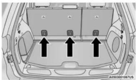 Top-down view of a car backrest with three black arrows pointing upward to internal compartments (no text or symbols)