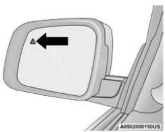 Close-up of a car side mirror with an arrow pointing to the left side (no text or symbols on the mirror itself)