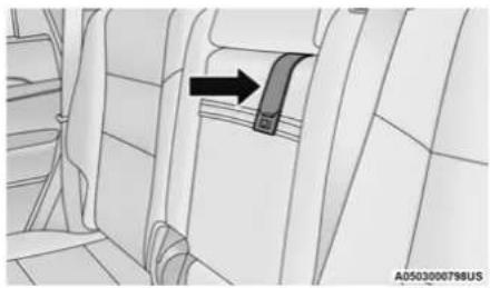 Interior view of a vehicle showing a car seatbelt with an arrow pointing to the seat (no text or symbols present)