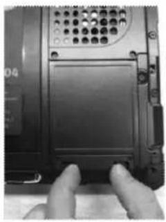 Close-up of hands installing a black plastic panel on a device (no visible text or symbols)