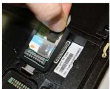 Close-up of a hand inserting a component into a device housing (no visible text or symbols)
