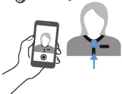 Illustration showing a hand holding a smartphone displaying a profile image and a person with a blue arrow pointing to the profile.