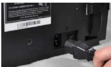 Close-up of a hand inserting a USB into a device with visible label and QR code on the cover