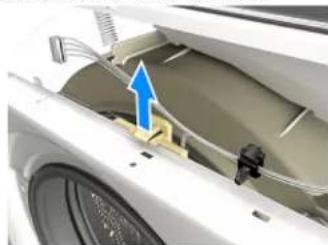 Close-up of a white washing machine's door with visible wiring and a blue arrow pointing to the component (no text or symbols)