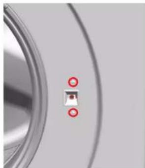 Close-up of a metallic circular object with two red circular markers on its surface (no text or symbols visible)