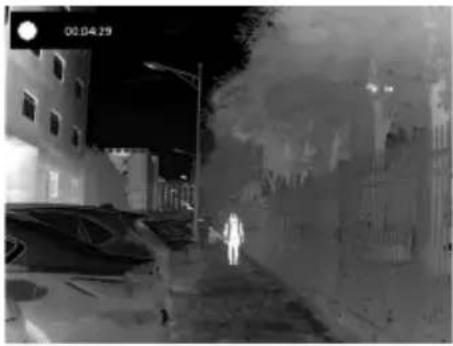 Night street scene with illuminated buildings and a vehicle, no visible text or symbols.