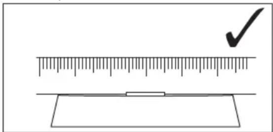 Diagram showing a ruler measuring a surface with a checkmark indicating the measurement point.