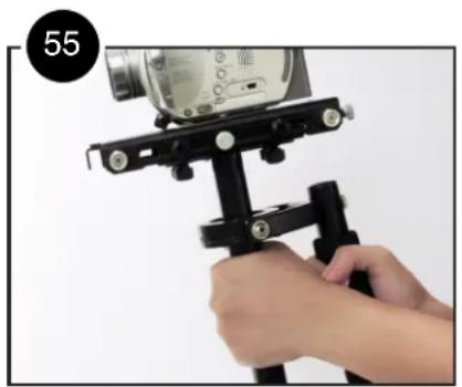Close-up of a hand holding a black tripod-mounted camera frame, no visible text or symbols