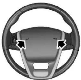 Interior view of a car steering wheel with two black arrows pointing to the dashboard (no text or symbols)