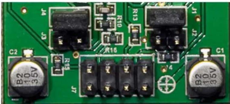 Close-up of a green printed circuit board with various electronic components and labeled pins (no readable text or symbols beyond component labels)