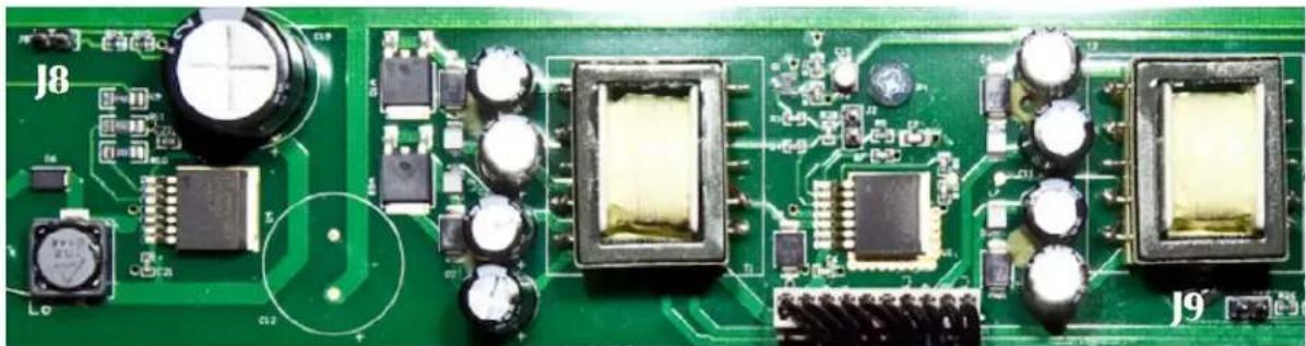 Close-up of a green printed circuit board with integrated circuits and capacitors (no readable text or symbols)