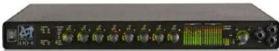 Front view of a black audio workstation with multiple knobs and a green waveform display (no visible text or labels)