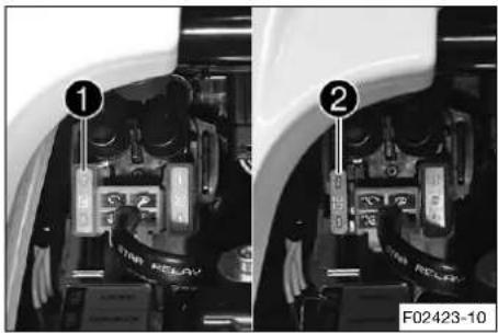 Technical diagram showing two views of a vehicle's rear suspension lock system with labeled components and part number F02423-10
