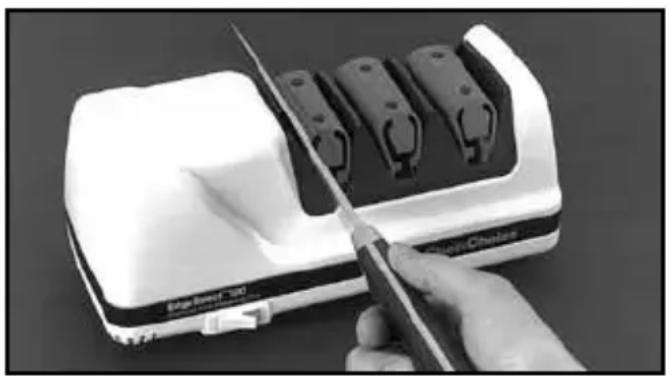 Close-up of a hand using a power tool to cut a white electronic device with multiple black components (no visible text or symbols)