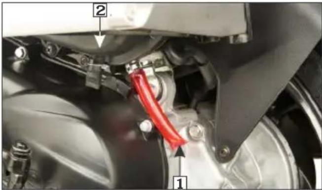 Close-up mechanical assembly diagram with numbered components and a red ribbon cable, likely indicating parts of a vehicle or automotive assembly.