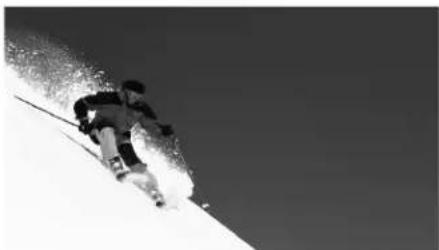 Black and white photo of a person skiing down a snowy slope (no text or symbols visible)