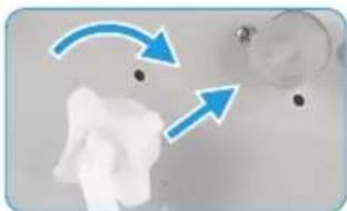 Close-up of a white object with two blue arrows pointing to a small object, no visible text or symbols.