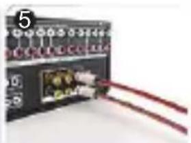 Close-up of an electronic control module with red cables connected to a central connector (no visible text or symbols)