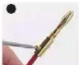 Close-up of a hand holding a pen or tool with a metallic tip, no visible text or symbols