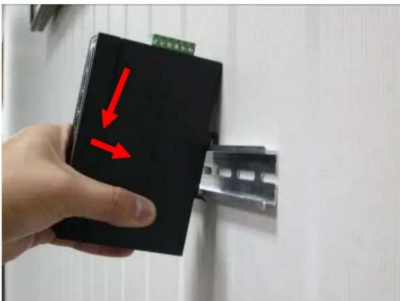 Hand holding a black electronic device with red arrows pointing to it, indicating a directional change or movement.
