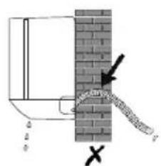 Diagram showing a pipe or pipe passing through a brick wall with an arrow and cross symbol indicating direction or force.
