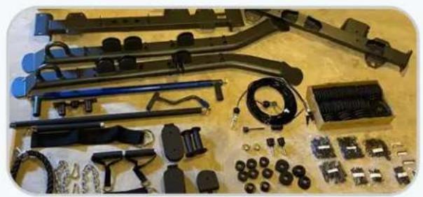 Assorted automotive electronic components laid out on a wooden surface, including tools, motors, and wiring (no visible text or labels)