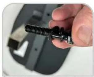 Close-up of a hand holding a black threaded mechanical component, with blurred background (no visible text or symbols)
