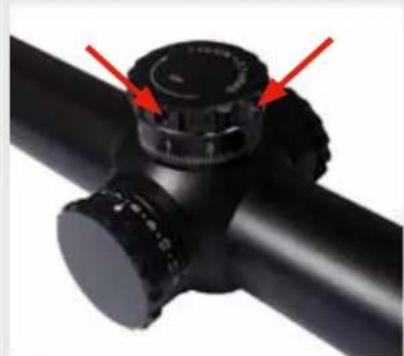Close-up of a black cylindrical object with red arrows pointing to a circular component (no text or symbols visible)