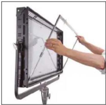 Person installing or adjusting a large screen mounted on a stand, no visible text or symbols